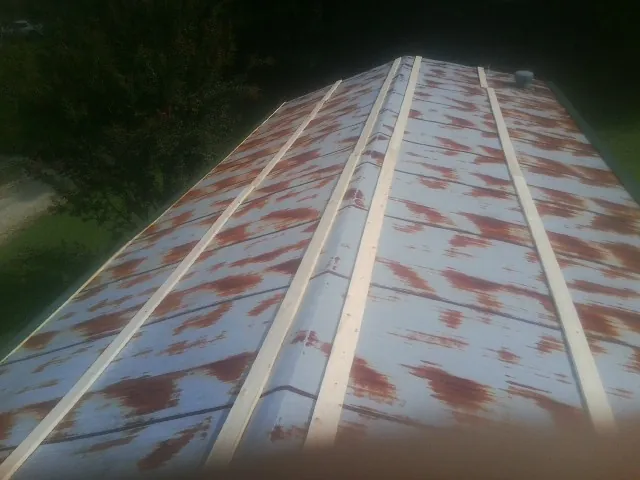 Rusted metal roof panels with new wood purlins before replacement — Storm Damage Roof Repair in Placitas by Roofing Brothers