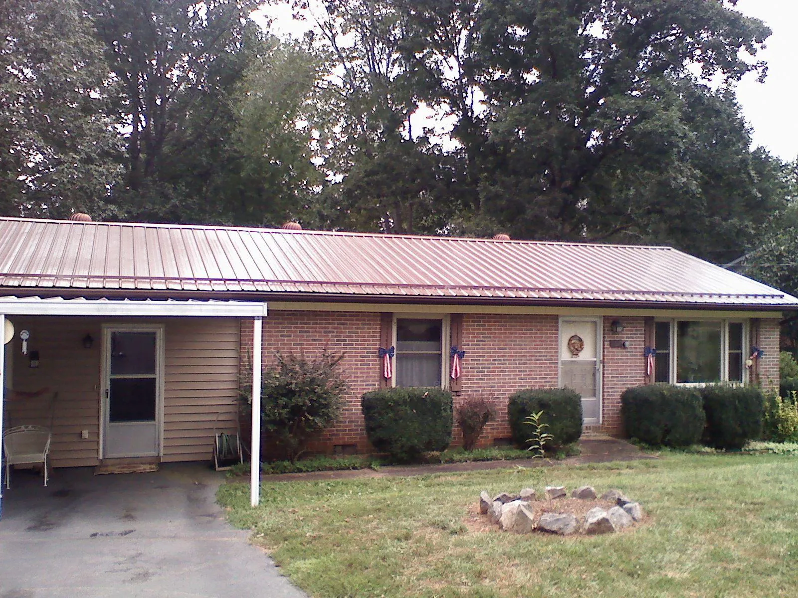 Bronze metal roof and carport on a brick ranch home — Roof Repair work by our crew in Placitas
